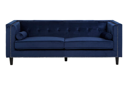 Blue velvet sofa with tufted backrest and nailhead trim on a white background
