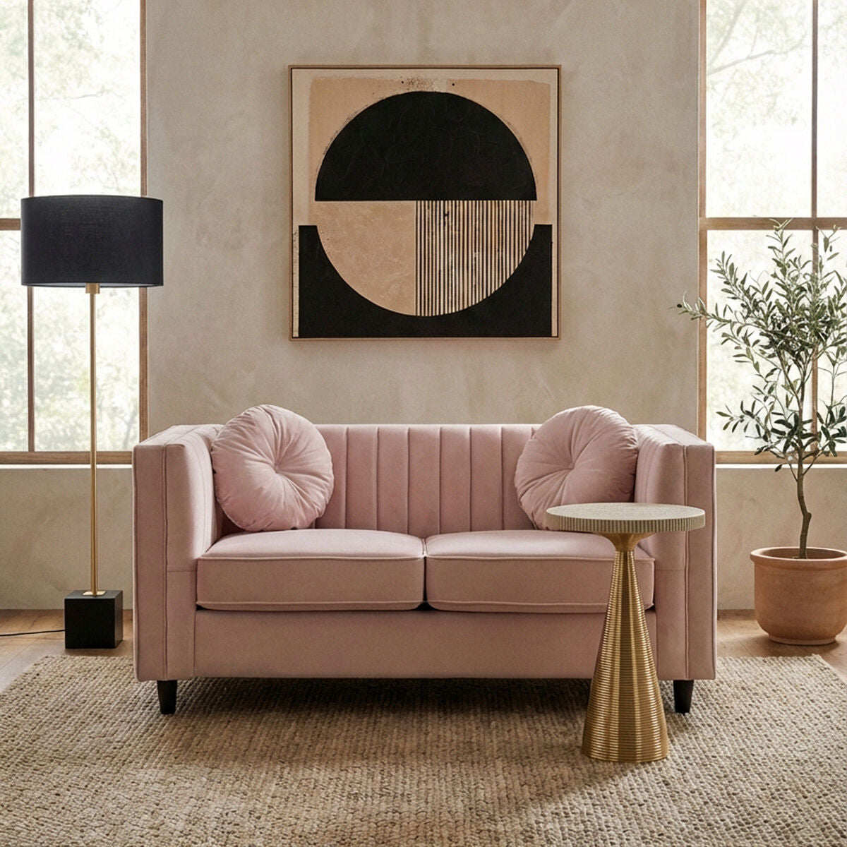 Pink sofa in a living room with abstract art on the wall and a side table.