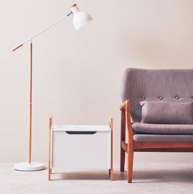 Modern living room with a gray sofa, white floor lamp, and wooden side table.