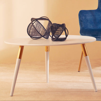 White table with gold legs holding decorative items, next to a blue chair on a wooden floor.