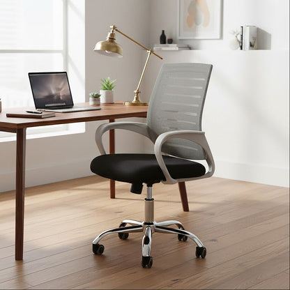 Modern office chair in front of a wooden desk with a laptop and decor items.