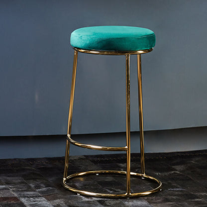 Teal bar stool with gold legs against a blue wall