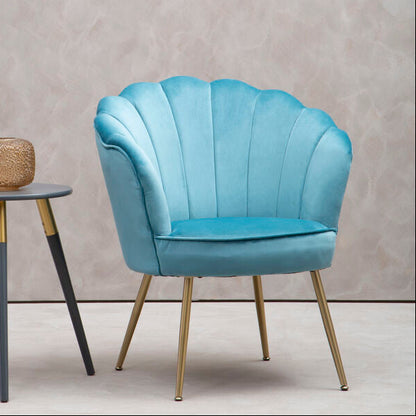Blue shell-shaped chair next to a small round table with a textured surface on a plain background