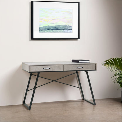 Modern desk with a framed artwork above it in a minimalistic room.