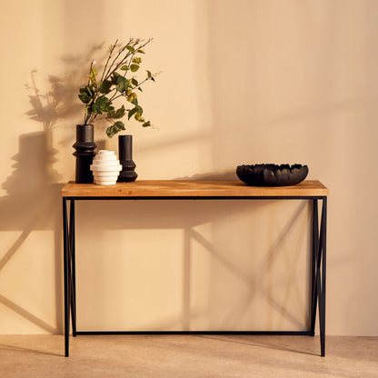 Wooden console table with decorative items against a beige wall