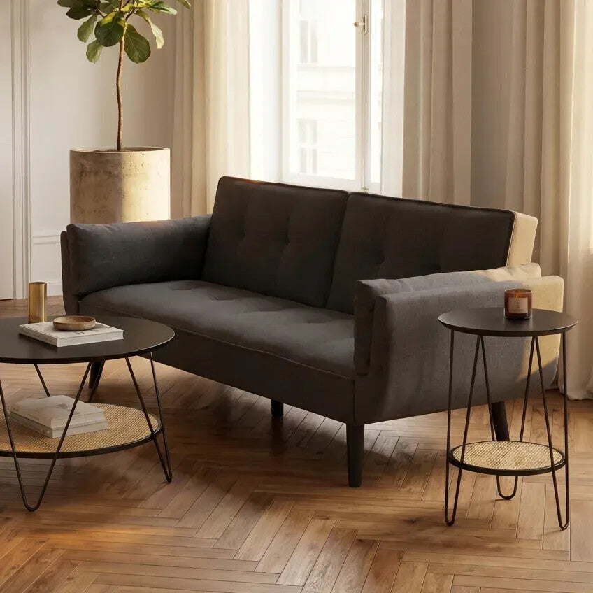 Gray sectional sofa in a living room with side tables and a lamp.