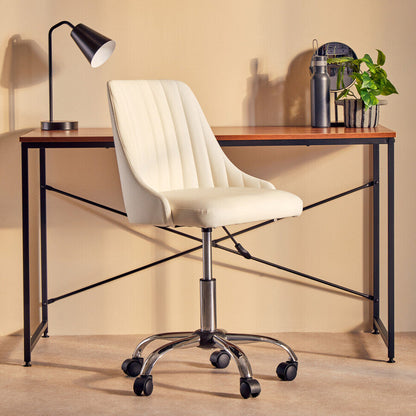 White office chair in front of a wooden desk with a lamp and plants on a beige wall background