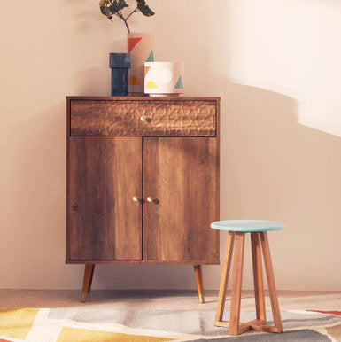 Wooden cabinet with decorative items and a stool in a room setting