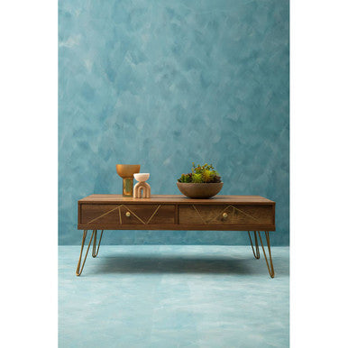 Wooden coffee table with decorative items against a textured blue wall.