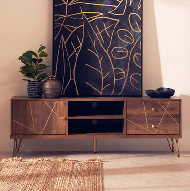 Wooden TV stand with decorative plant and abstract wall art in a room.