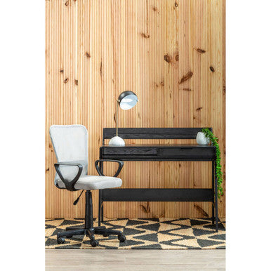 Black desk with white chair against a wooden paneled wall.