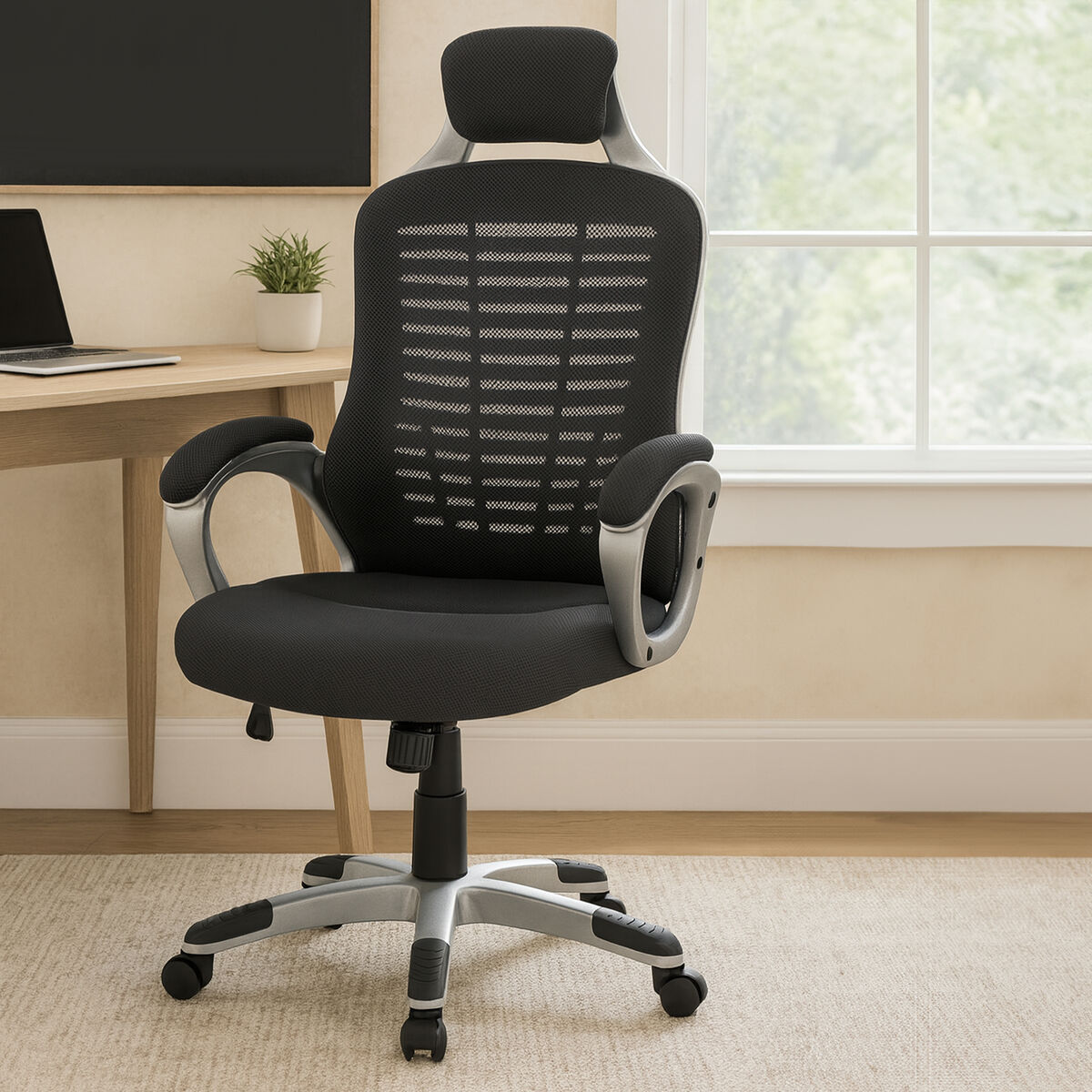 Black office chair in an office setting with a desk and window in the background.