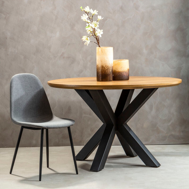 Wooden dining table with black metal legs and a gray chair against a gray wall.