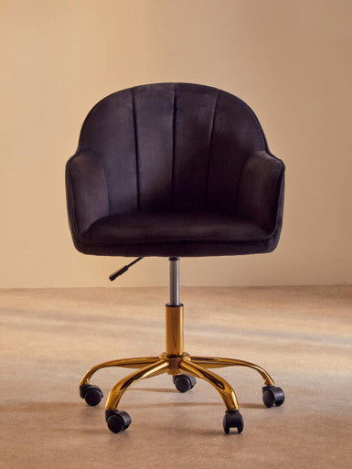 Black office chair with gold base on a beige floor