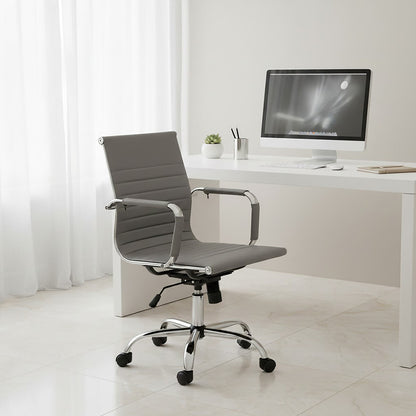 Modern office chair in front of a white desk with a computer setup.