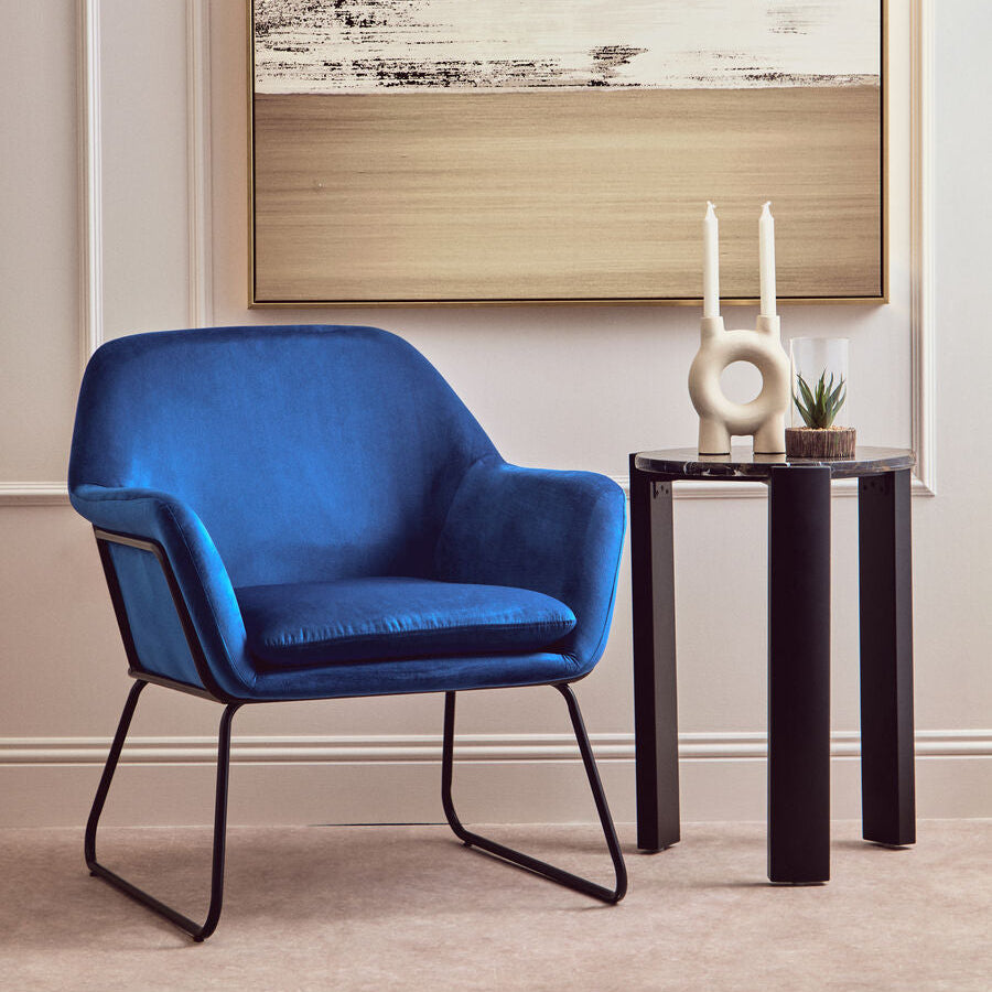 Blue armchair in a room with a abstract painting on the wall