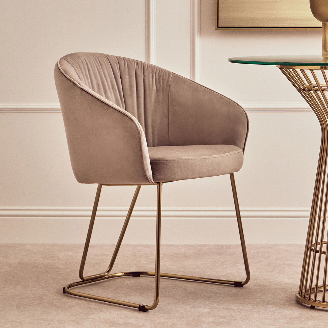 Beige armchair with gold legs in a modern interior setting