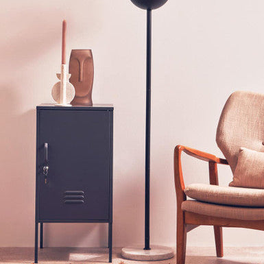 Modern interior with a floor lamp, cabinet, and chair.