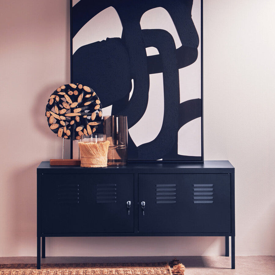 Navy blue cabinet with abstract art and decorative items in a room.