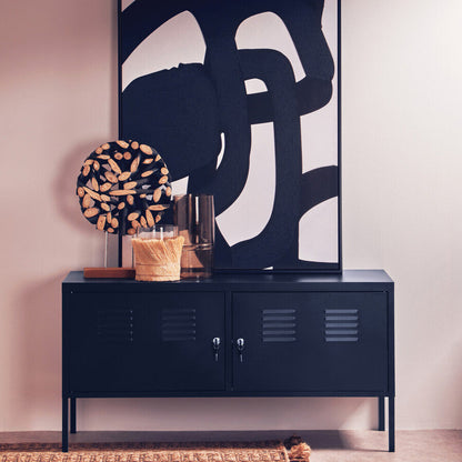 Navy blue cabinet with abstract art and decorative items in a room.