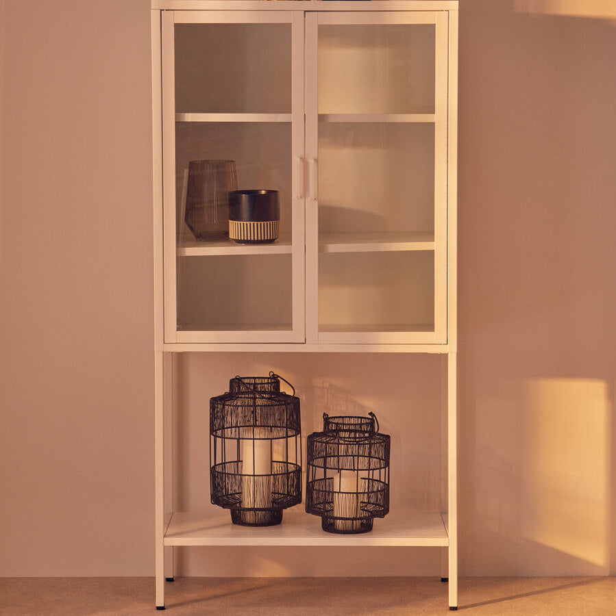 White glass-fronted cabinet with decorative items against a beige wall