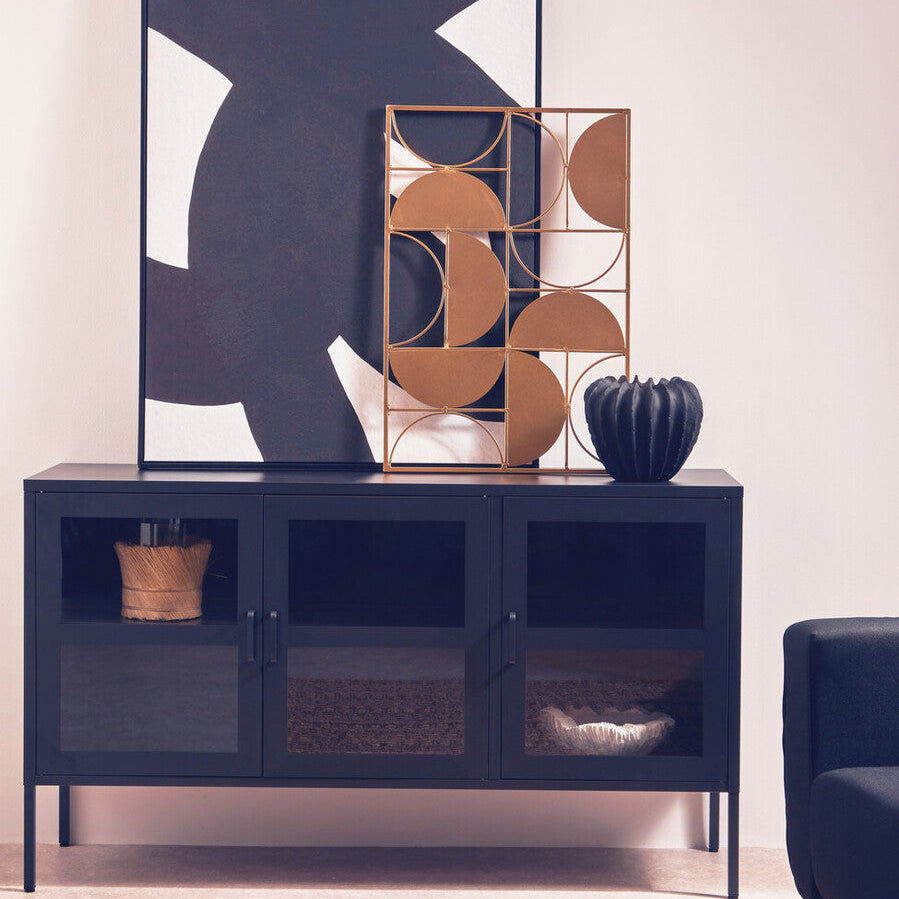 Modern interior with a dark blue sideboard, abstract art, and decorative items.