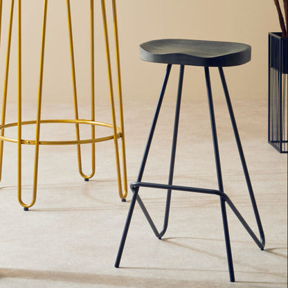 Two bar stools with different metal legs in a room with a plant and open door.