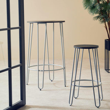 Two black bar stools with metal legs on a wooden floor.
