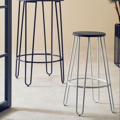 Two black bar stools with metal legs on a light wooden floor.