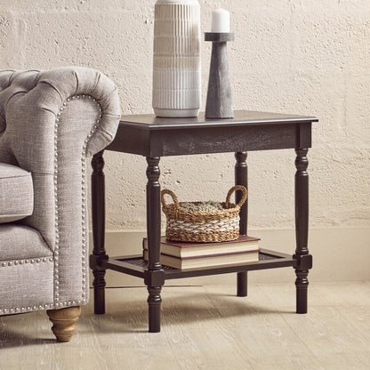 End table with decorative items next to a gray sofa against a beige wall.