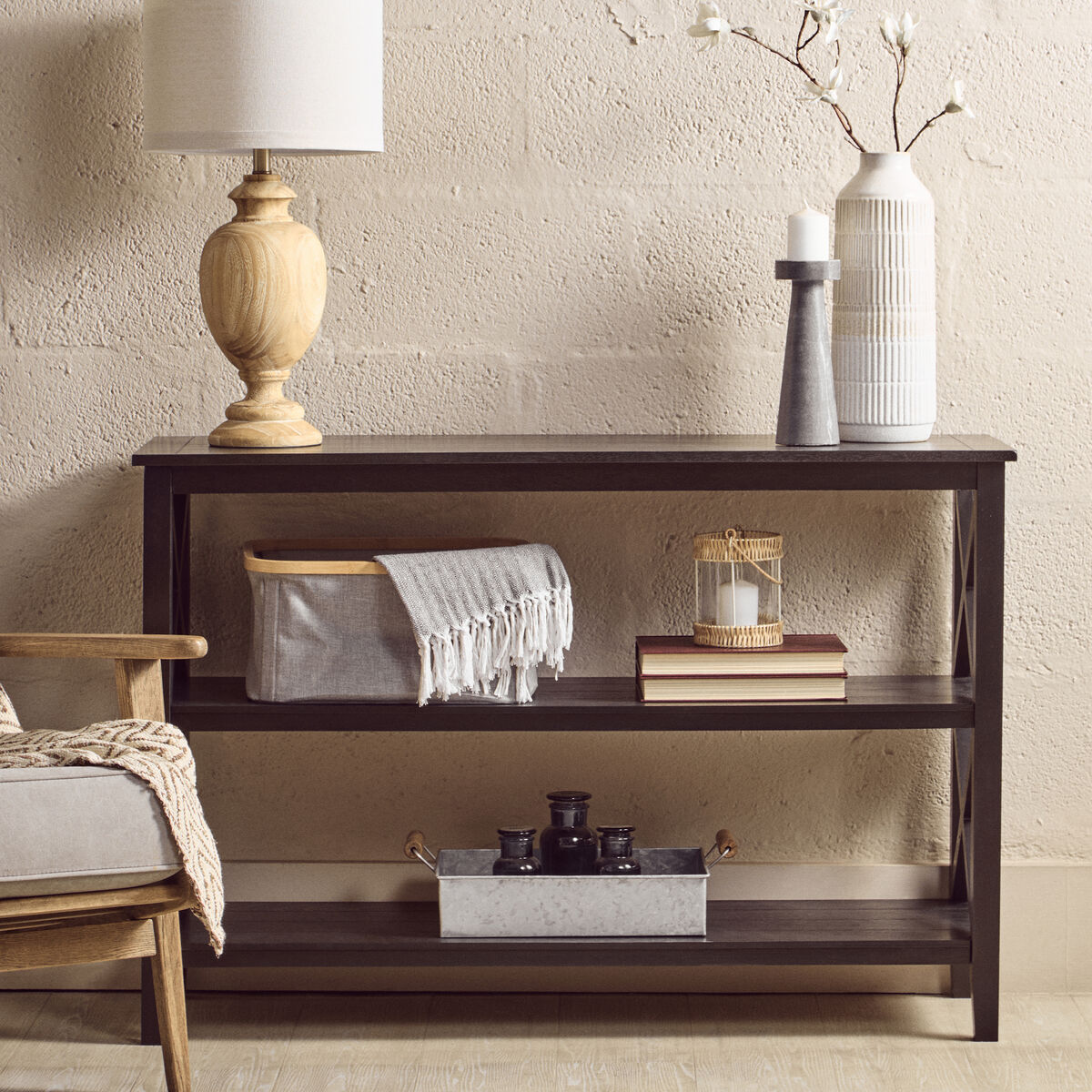 Dark wooden console table with decorative items against a beige wall