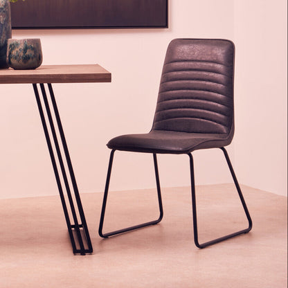 Modern chair next to a wooden table with decorative items in a room.