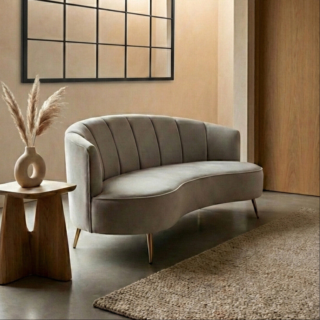 Modern living room with a gray sofa, wooden side table, and decorative mirror.