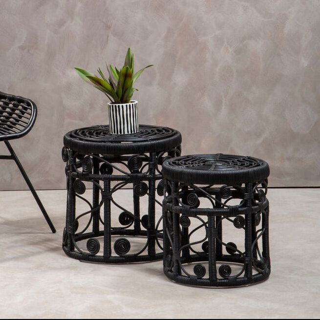 Black woven side table and chair against a gray wall.