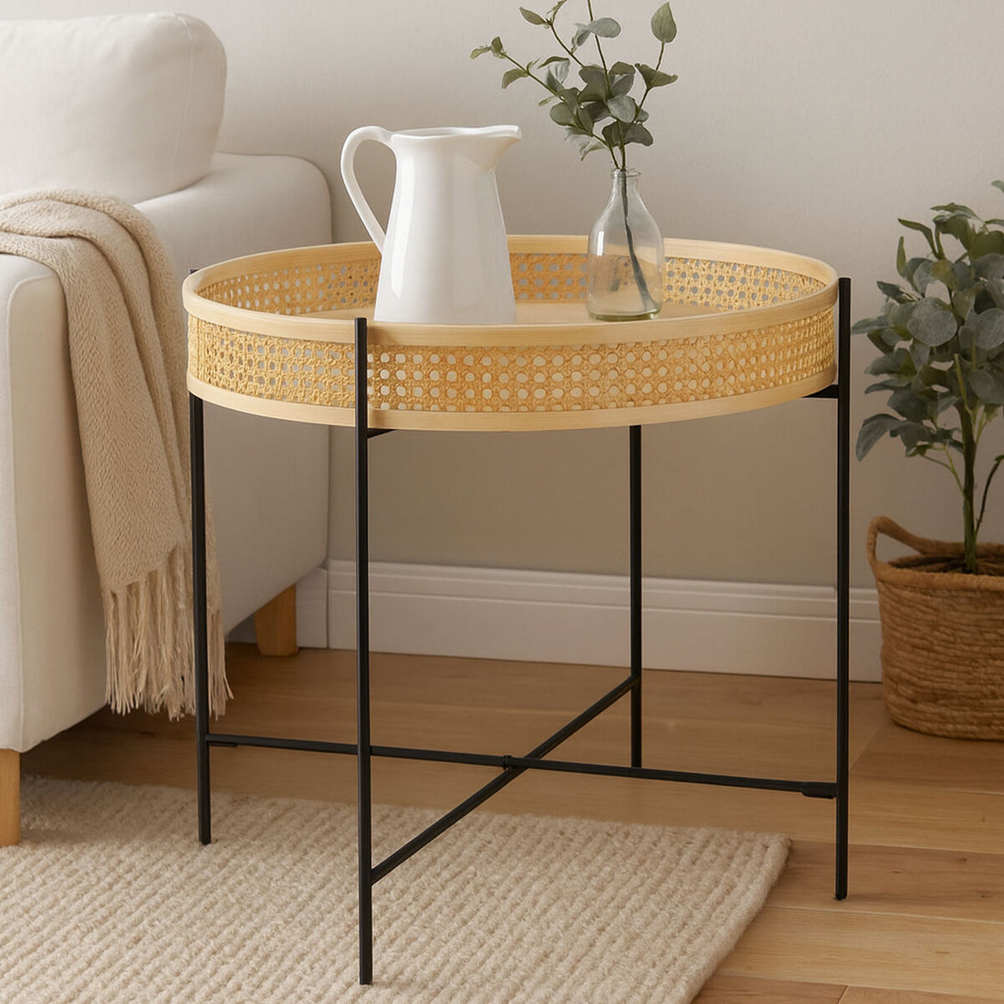 Round wicker side table with black metal legs in a living room setting.