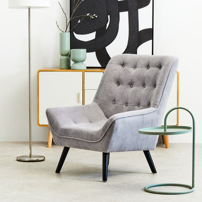 Gray armchair in a modern living room with abstract art and side table.