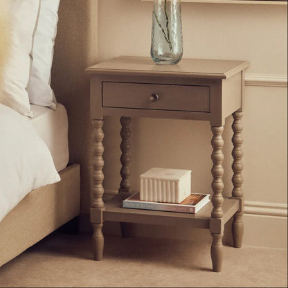 Neatly arranged bedroom with a bed, nightstand, and decorative elements.