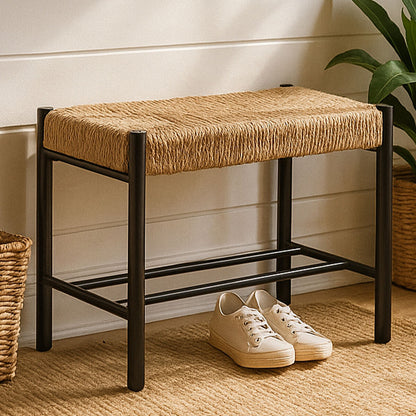 Woven stool with black frame and beige cushion on a wooden floor with white wall background