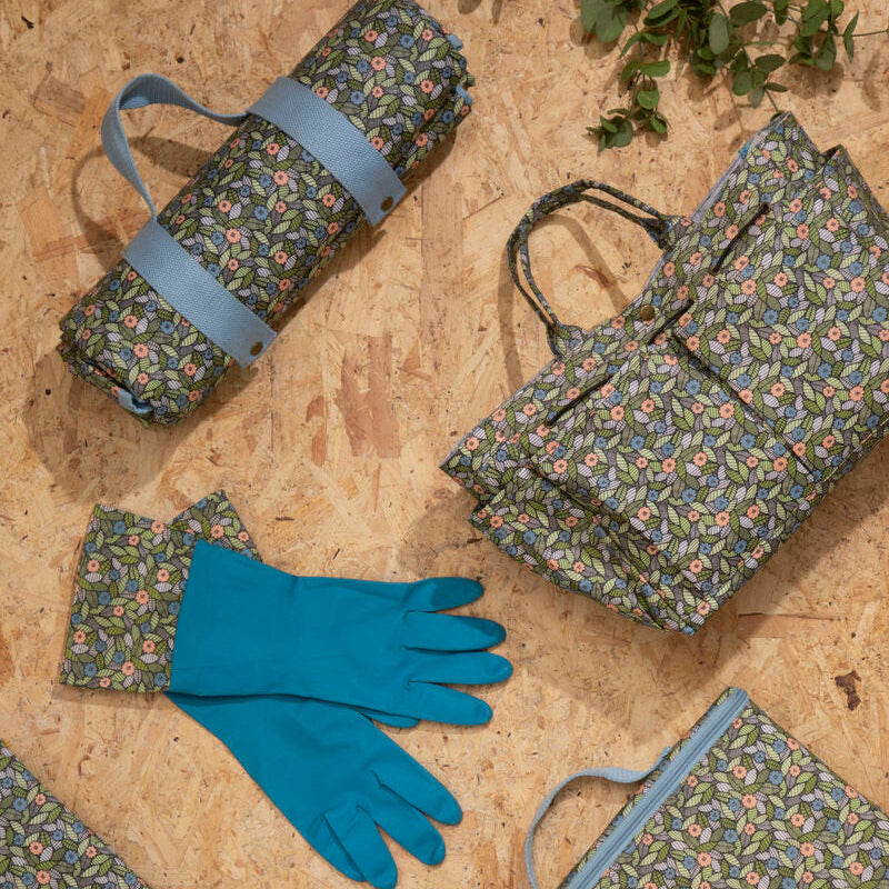 Floral-patterned bags and a blue glove on a textured surface