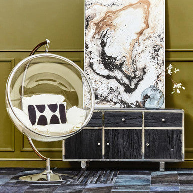 Modern interior design with a black and gold chair, abstract painting, and decorative items against a green wall.