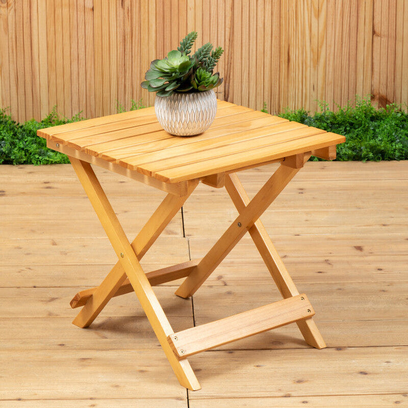 Wooden folding table with a plant on a wooden deck