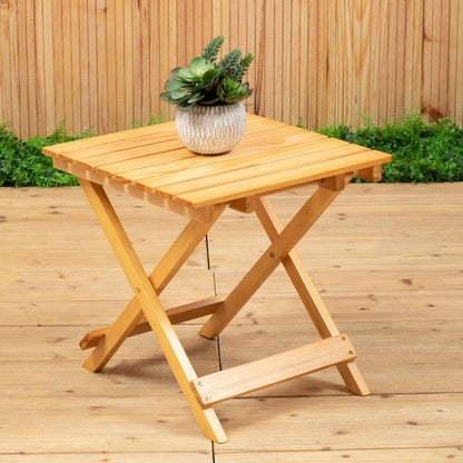 Wooden folding table with a plant on a wooden deck