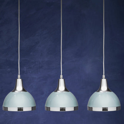 Three pendant lights with light blue shades and chrome bases against a dark blue background