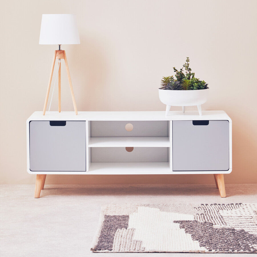 White entertainment console with wooden legs in a minimalistic room.