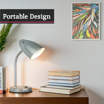 Desk with lamp, books, and framed artwork on a wall.