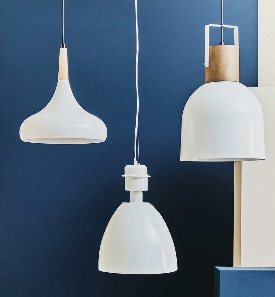Three white pendant lights against a blue wall
