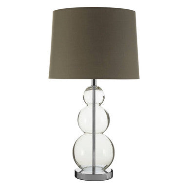 Table lamp with a clear glass base and dark green shade on a white background