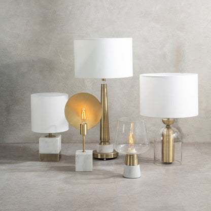 Collection of various lamps on a textured surface with a neutral background
