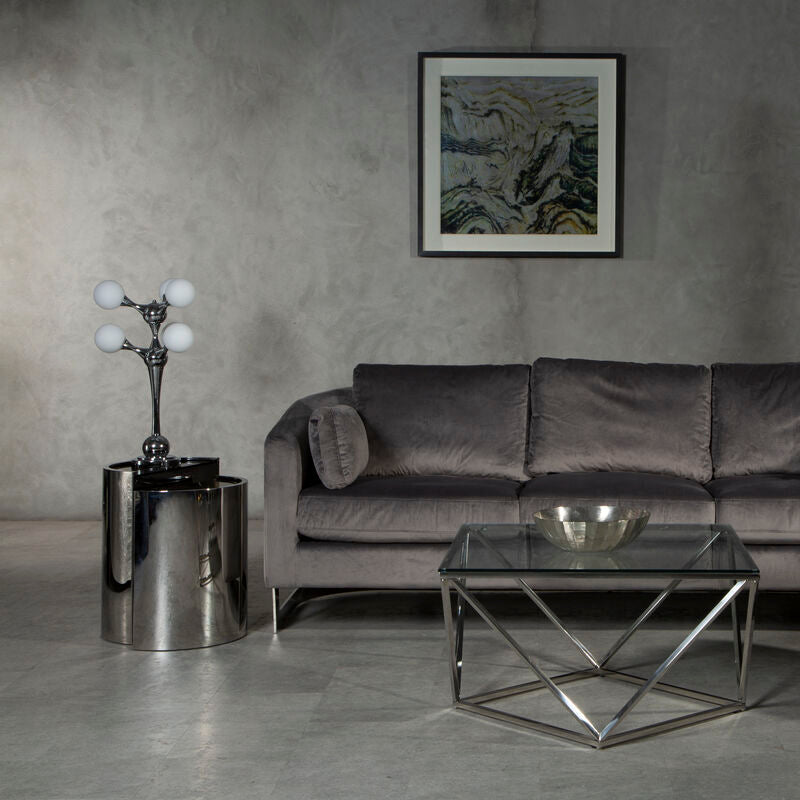 Modern living room with a gray sofa, coffee table, and side table against a textured wall.