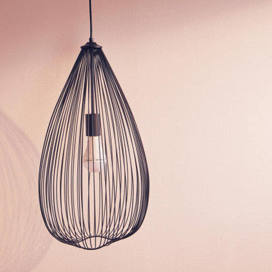 Wire pendant light against a pink background